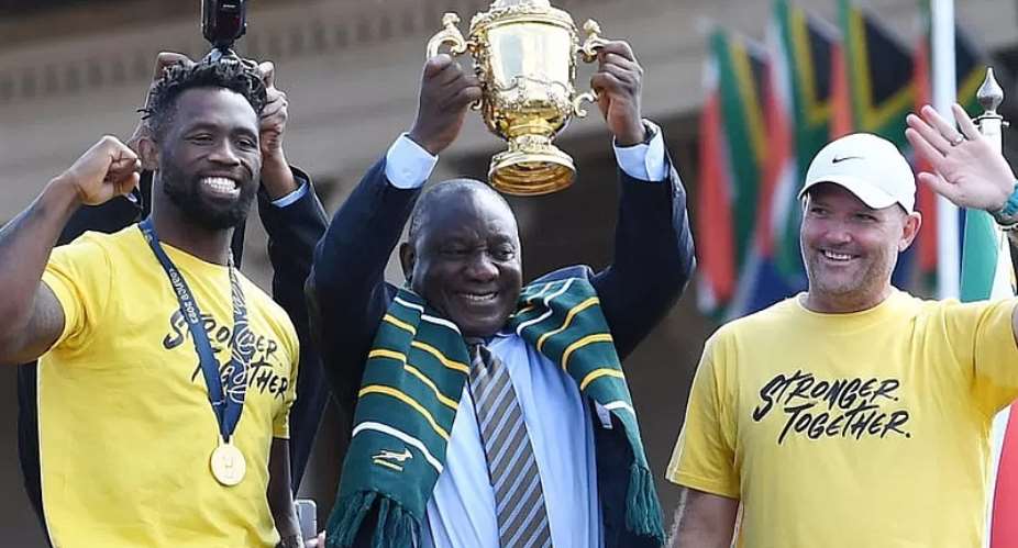 GETTY IMAGESImage caption: Fans turned out to see from left to right team captain Siya Kolisi, President Cyril Ramaphosa and head coach Jacques Nienaber lift the trophy