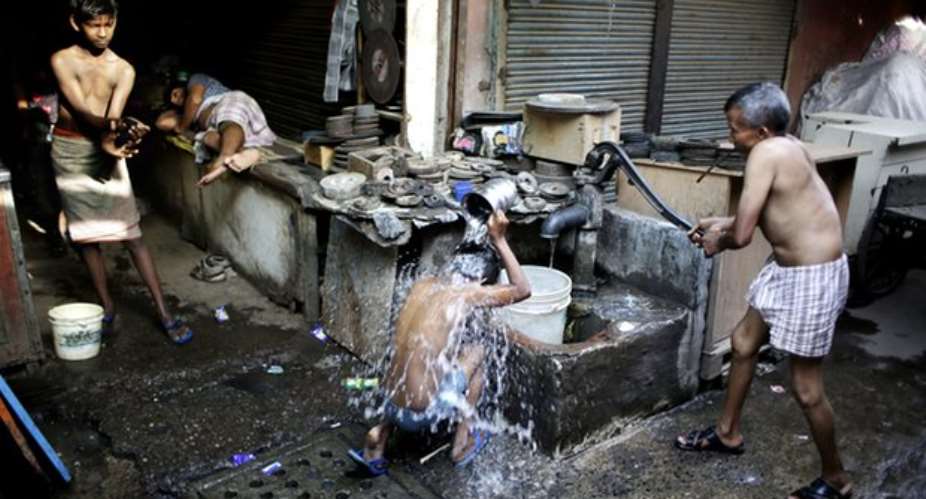 Indian migrant daily wage workers bath at a public well in New Delhi. New information shows that poverty in China and India is worse than previously thought. Photograph: Altaf QadriAP