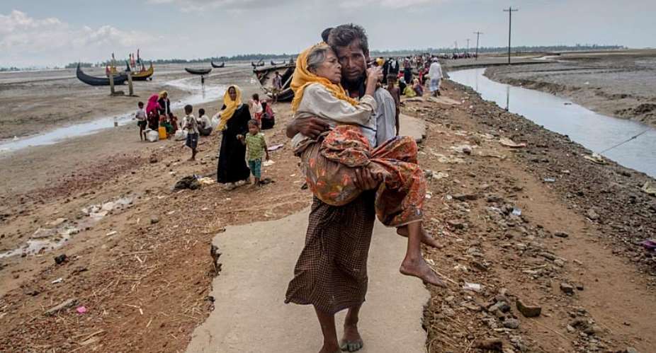 Abdul Kareem, a Rohingya Muslim, carries his mother, Alima Khatoon, to a refugee camp after crossing from Burma into Bangladesh on Sept. 16, 2017.  2017 Dar YasinAP