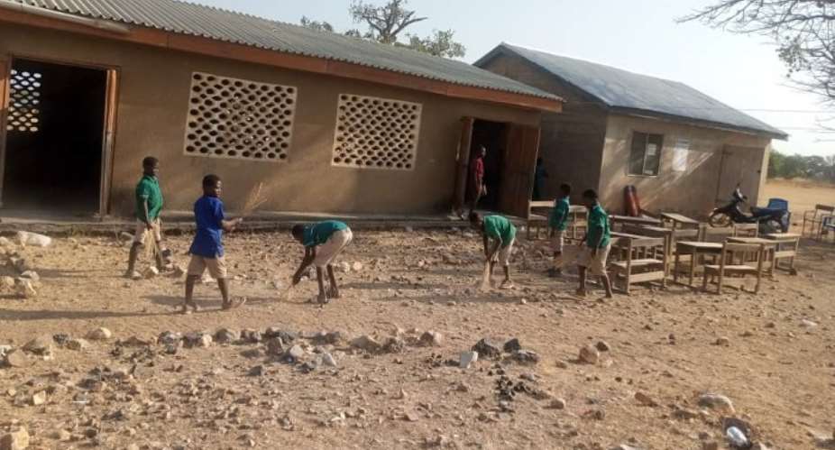 School children cleaning their school on first day of reopening