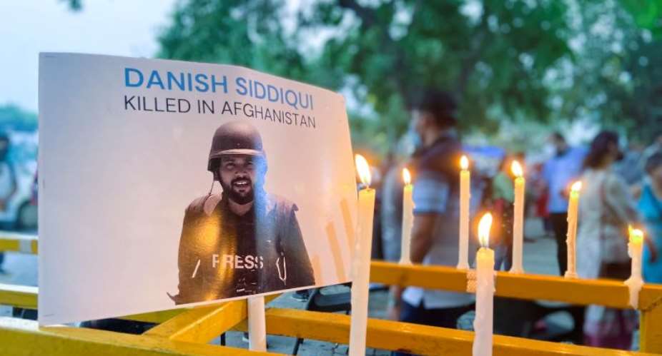 Candles are lit next to a photo of Reuters journalist Danish Siddiqui, who was killed covering a clash between Afghan forces and the Taliban near a border crossing with Pakistan, during a July 17, 2021, vigil in New Delhi, India. According to CPJ research, at least 27 journalists were killed due to their work in 2021. ReutersAnushree Fadnavis