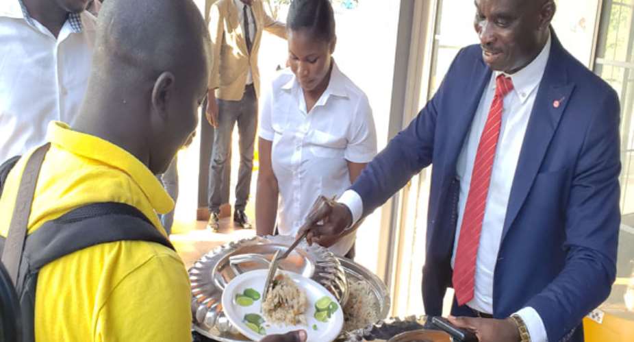 Isaac Owusu serving food to the journalists