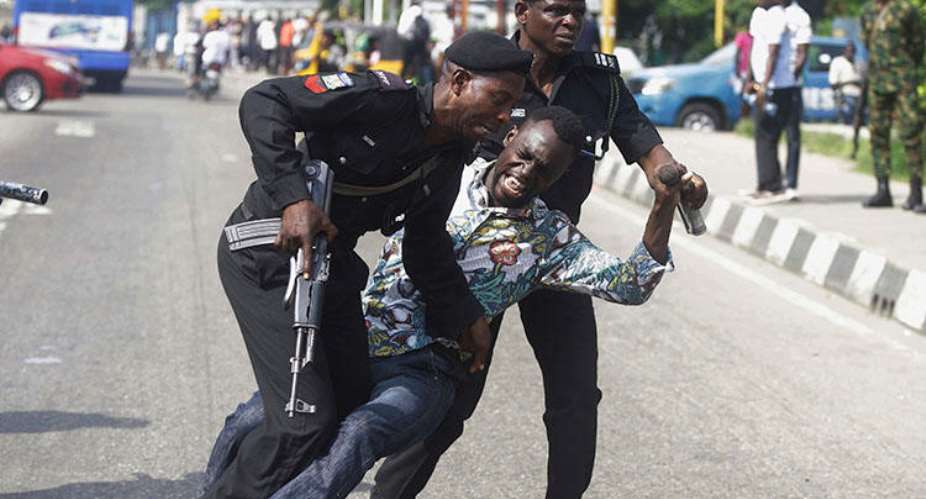 Police officers detain Sahara Reporters journalist Victor Ogungbenro during a protest in Lagos, Nigeria, on August 5, 2019. Staff at the online newspaper report sustained harassment targeting them and their website. APSunday Alamba