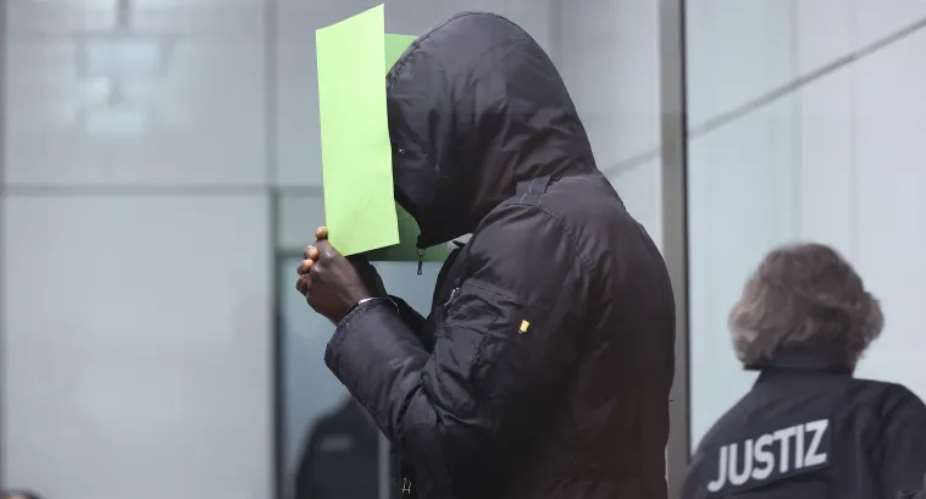 Gambia's Bai Lowe holds a folder in front of his face at a regional court in Celle, Germany, on April 25, 2022. The court sentenced Lowe to life imprisonment on November 30, 2023, for his role in the murder of Gambian journalist Deyda Hydara. Ronny HartmannPool Photo via AP