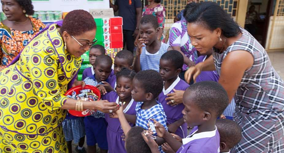 Mrs Lordina Mahama sharing candies to the children of Osu Children's home