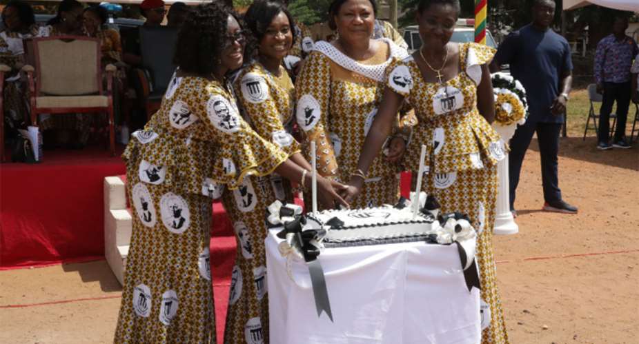 Mrs. Akufo Addo cutting the anniversary cake staff of the Achimota Primary School.