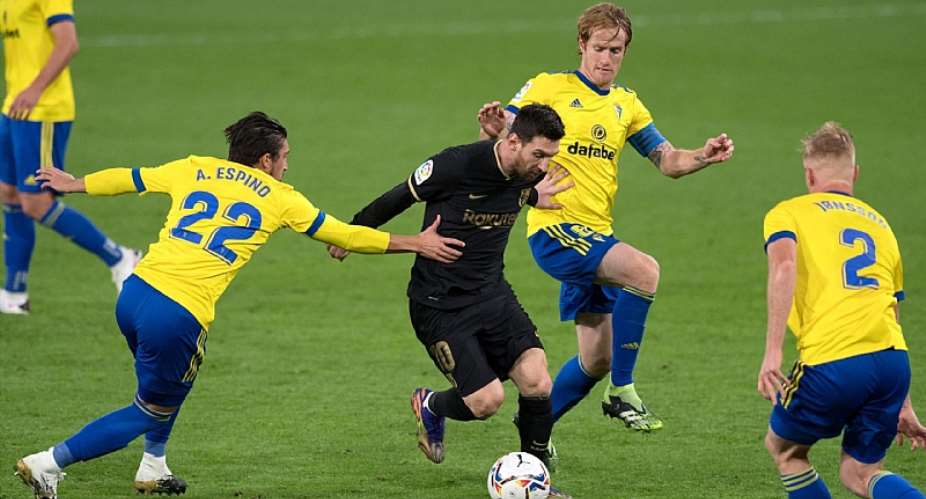 Cadiz players surround Lionel MessiImage credit: Getty Images