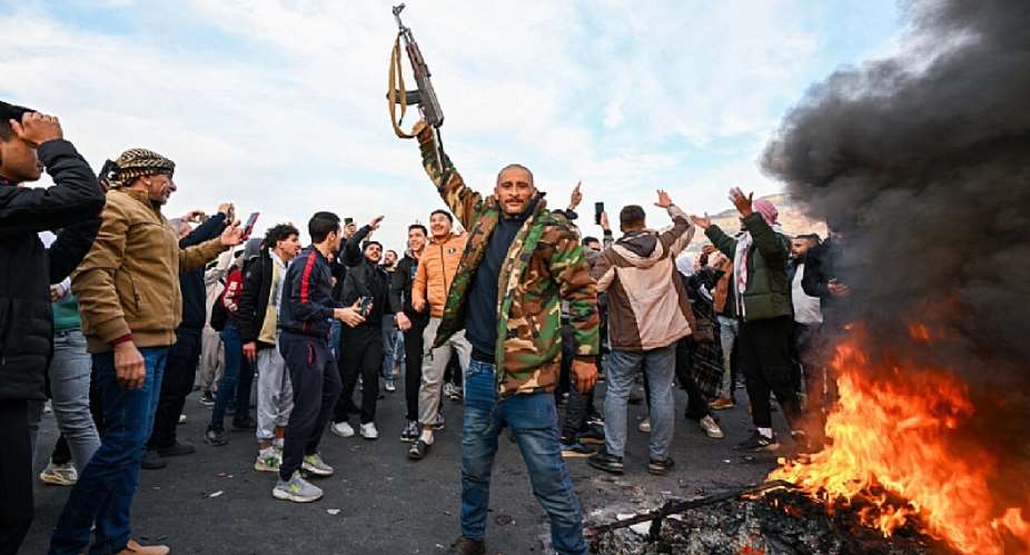 People celebrate the fall of the Assad regime at Umayyad Square in Damascus on December 8, 2024.  Louai Beshara, AFP