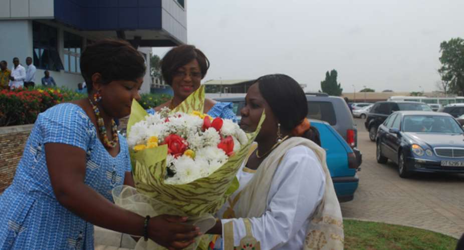 Cecilia Dapaah receiving a bouquet of flowers on arrival