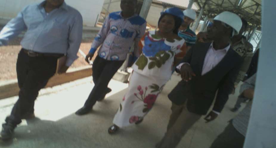 Hon. Lawyer Charity Akua Foriwaa Dwommor , middle taken round the hospital by engineers on site during the tour.