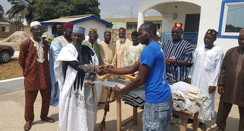 Chief Sissy left,presenting the items to Shafiu Mohammed, Al-Musahidin group leader.