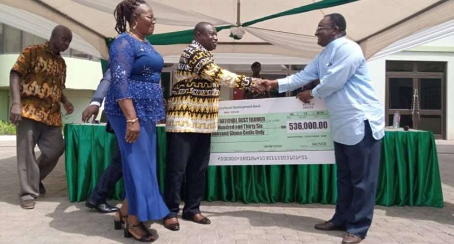 Dr. Owusu Afriyie Akoto presenting a Cheque to the National Best Farmer