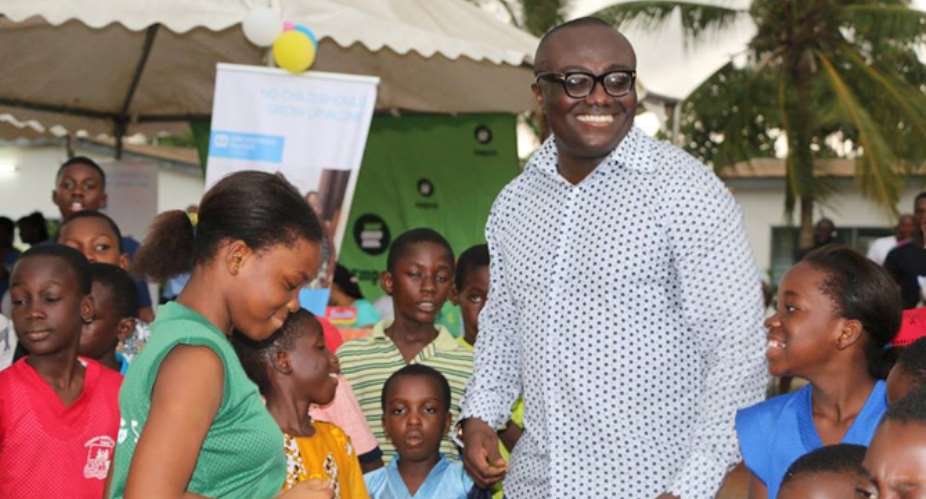 Bola Ray in a pose with some of the children after the donation