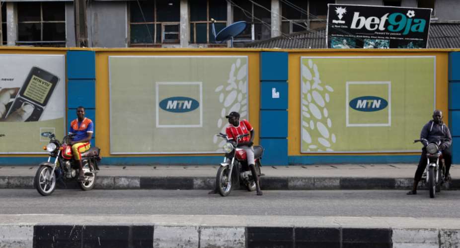 Men sit on motorbikes in front of advertising posters for MTN telecommunication company along a street in Lagos, Nigeria on August 28, 2019. MTN is one of four internet providers blocking the Peoples Gazette site. ReutersTemilade Adelaja