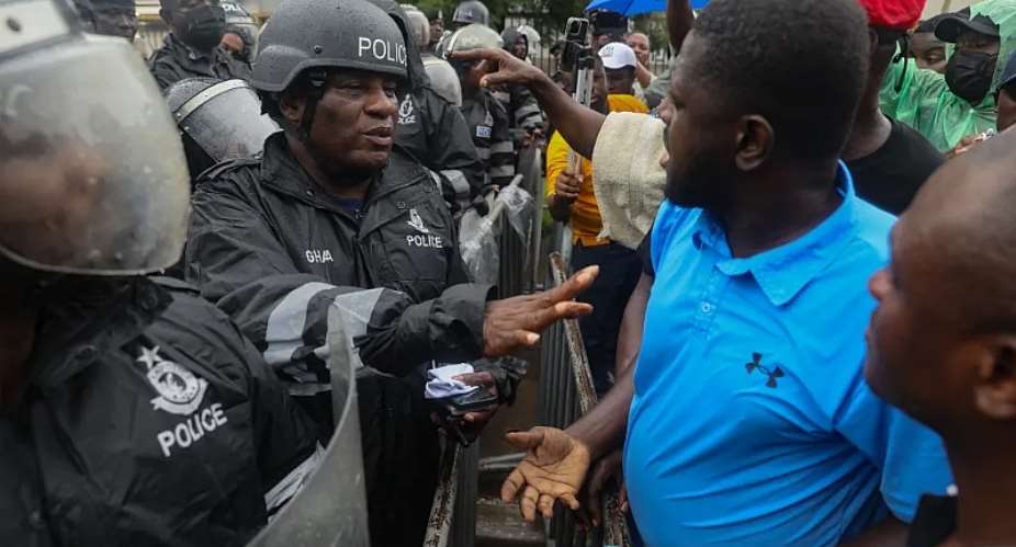 A Ghanaian police officer gestures towards protestors during a demonstration in Accra on September 23, 2023. Mohammed Aminu M. Alabira, a correspondent for Citi FM, was covering the ruling New Patriotic Party parliamentary primaries on January 27, 2024, in Yendi when he says a NPP parliamentarian and party supporters punched and kicked him. AFPNipah Dennis
