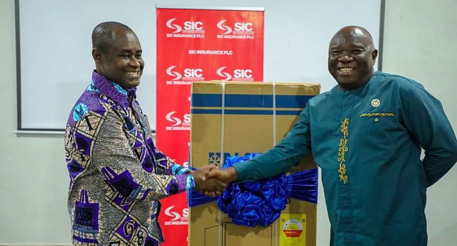 Mr James Agyenim-Boateng (left), Managing Director of SIC Insurance PLC, presenting an award to a top-performing agent.