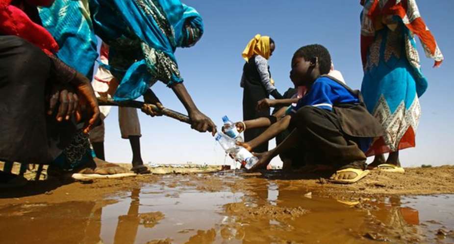 A Sudanese woman fills water bottles held by a young boy in North Darfur state. Within two decades 600 million children will be in regions enduring extreme water stress. Photograph: Ashraf ShazlyAFPGetty Images