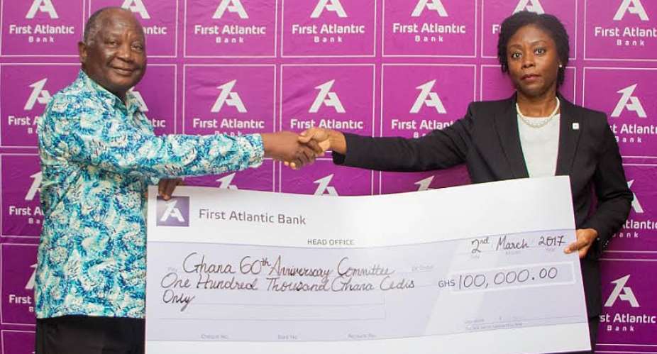 Patience Asante presents the dummy cheque to Ken Amankwah