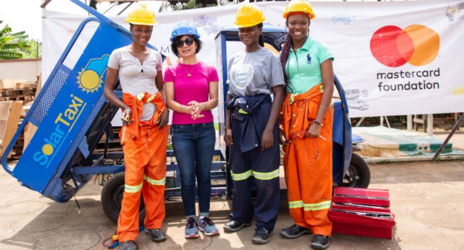 President And CEO Of Mastercard Foundation, Reeta Roy, With Members Of The Solar Taxi All Female Engineering Team. The Group Are Standing In Front Of A Prototype Mini-Van During Their Visit To Kumasi Hive, A Multi-Space Innovation Hub In Kumasi, Ghana
