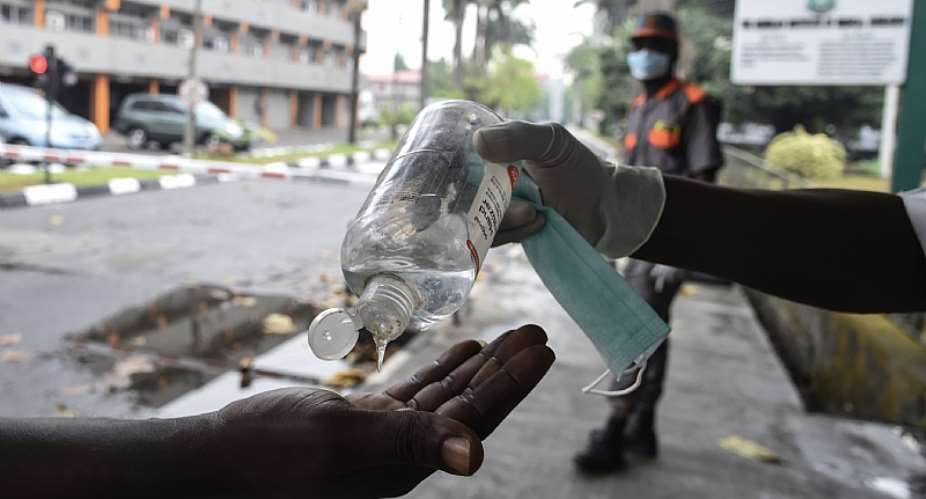 A visitor sanitises hands before entering a state hospital at Yaba, Lagos. Hospitals like this are likely to suffer power cuts as lock down force Nigerians to stay at home and consume more power.   - Source: Photo by Pius Utomi EkpeiAFP via Getty Images
