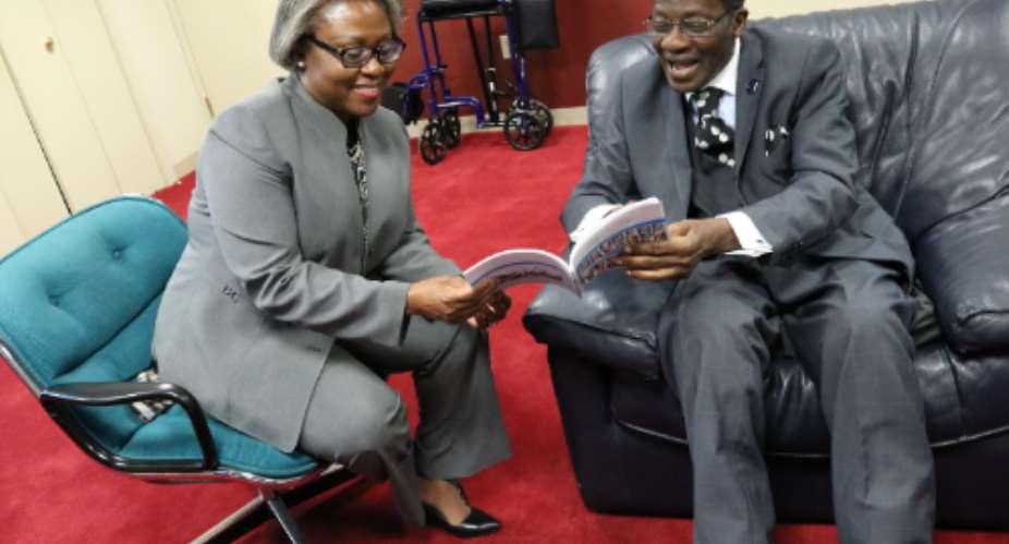 Daasebre Oti Boateng explaining a point in the book to Ambassador Pobee Left