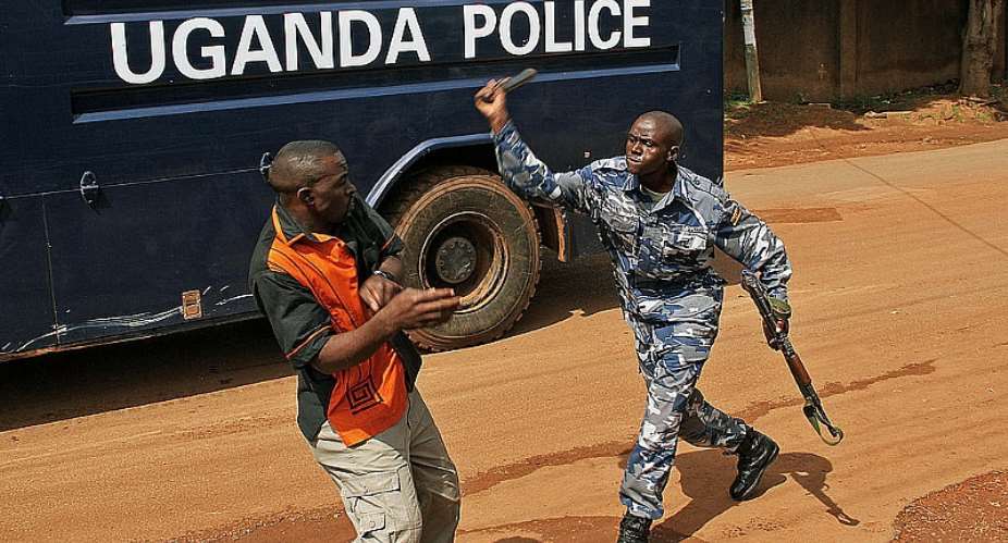 A policeman beats up a journalist in Kampala outside the Daily Monitor and Red Pepper newspapers during a protest at the temporary closure of two newspapers by armed police in May 2013.  - Source: Isaac KasamaniAFP via Getty Images
