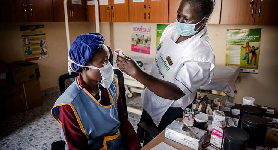 A doctor measures a workeramp;39;s temperature in Kitui, Kenya. With technology, AI and human resources, Africaamp;39;s health systems can take on COVID-19. - Source: Photo by LUIS TATOAFP via Getty Images