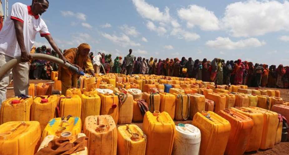 Internally displaced Somali women gather with their jerrycans to receive water Photograph: Feisal OmarReuters