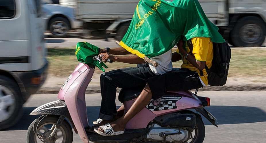 Supporters of ruling party Chama Cha Mapinduzi CCM - Party of the Revolution drive with the partyamp;39;s flag on their heads on a motorcycle. - Source: DANIEL HAYDUKAFP via Getty Images