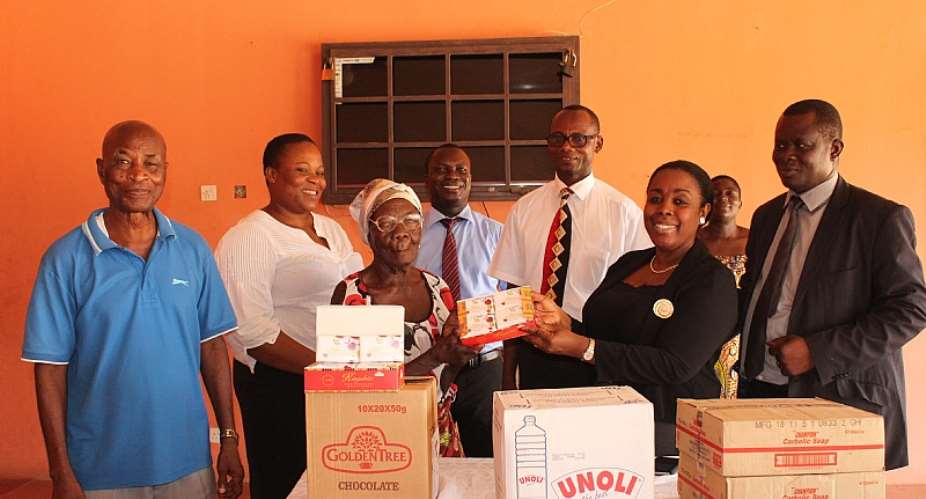 Mrs. Obuobi, second right presenting the items tothe inmatesof the Weija Leprosarium. Looking on are some members of theDepartment