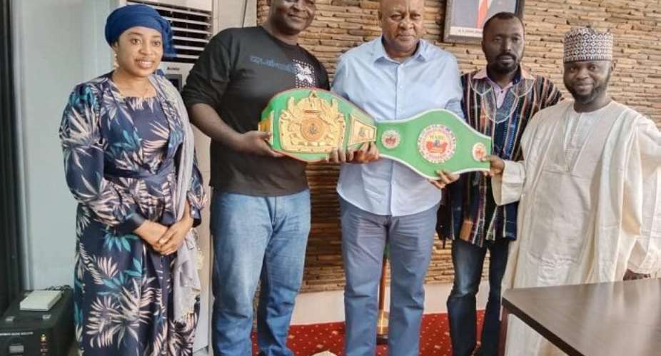 WABU  heavyweight champion Haruna Osuman presents titles to former President Mahama