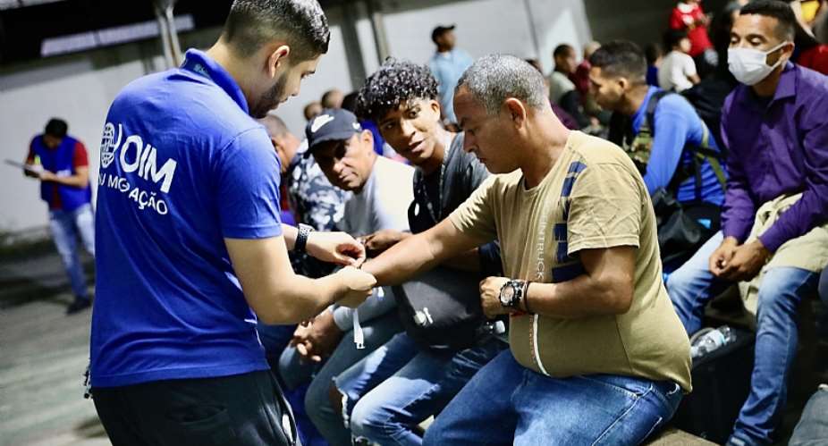 IOM staff helping migrants and refugees from Venezuela before boarding a relocation flight from Boa Vista in southern Brazil. Photo: IOM/Gema Cortes