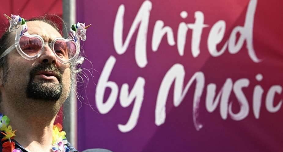 A man cheers prior to the opening ceremony of the Eurovision Song Contest 2026 at the City Hall Square in Vienna, Austria on May 10, 2026. - AFP - TOBIAS SCHWARZ