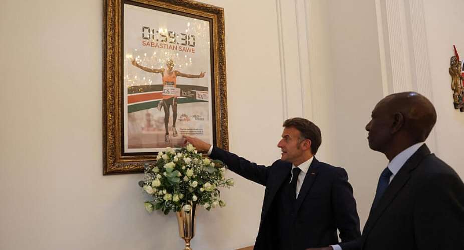 Frances President Emmanuel Macron (2nd R) points to a frame photograph of Kenyan marathon runner Sabastian Sawe, crossing the finish line to win the London Marathon after breaking a historic world record, next to Kenyan President William Ruto (1st R) during a reception at State House ahead of the Africa Forward: Africa- France Partnerships for Innovation and Growth Summit in Nairobi, on May 10, 2026. - AFP - LUDOVIC MARIN