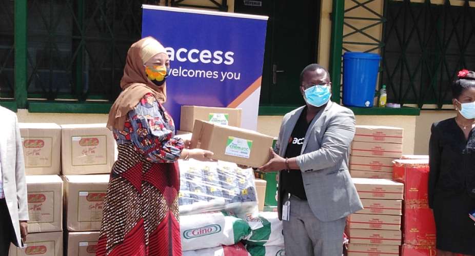 Hajia Salma left receiving the items from Mr. Jude Atubigah of the Access Bank
