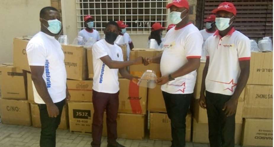 Bannerman (in cap) presenting the items to Samuel Adobah, supported by other staff