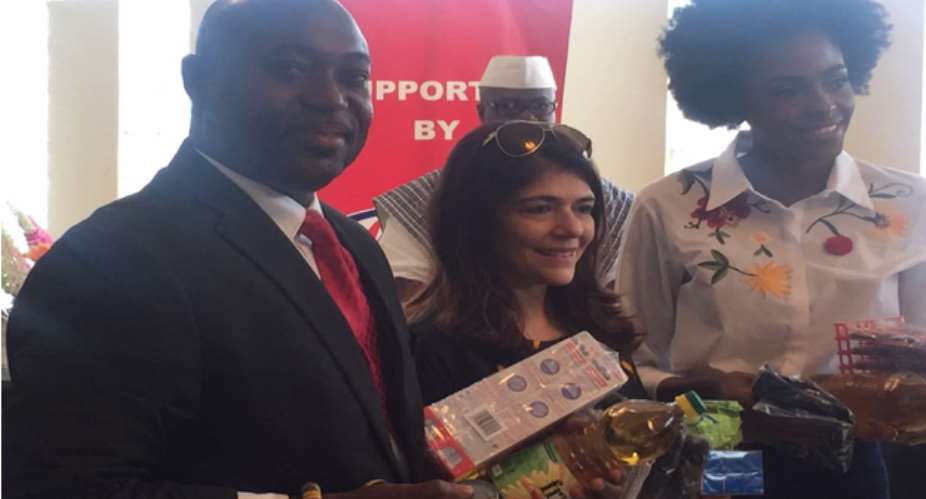Mr. William Nyarko (left) displaying some of the items received from Ms. Sonya Sadhwani (middle)