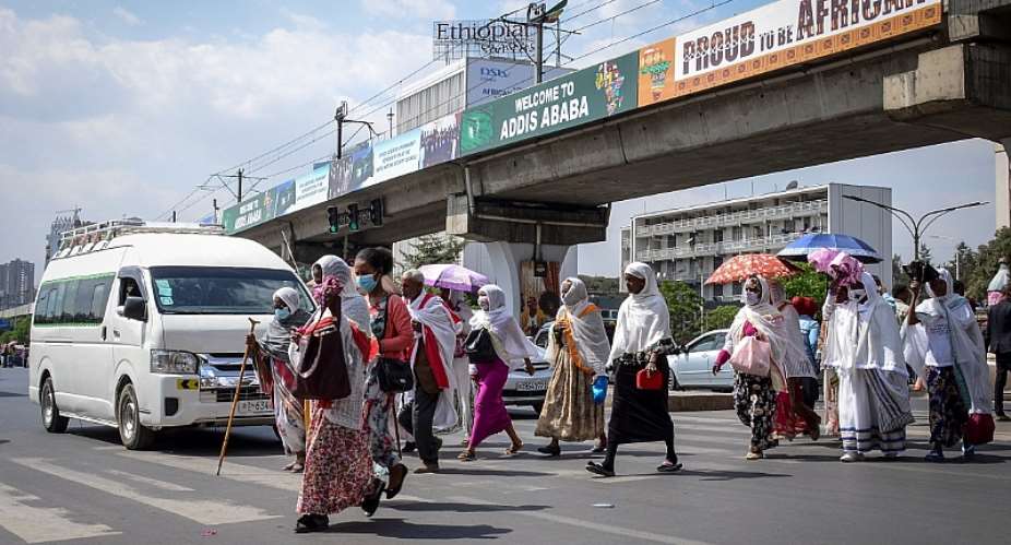 Pedestrians cross a street in downtown Addis Ababa, Ethiopia, on February 15, 2022. Ethiopian authorities on May 13 revoked the press accreditation of Economist correspondent Tom Gardner, and expelled him from the country. AP Photo