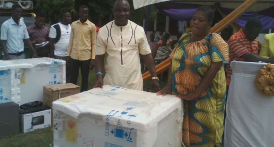 Hon. John Kofi Donyina presents a deep freezer to one of the beneficiaries