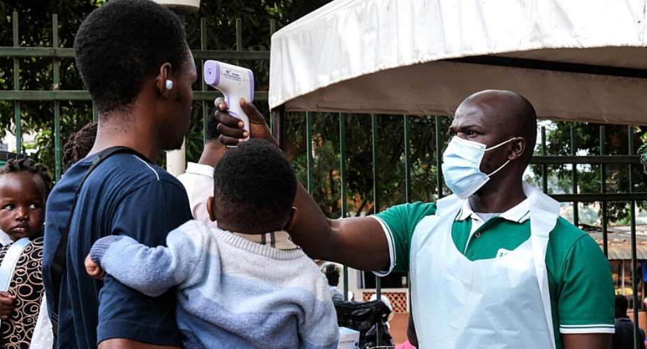 A health official uses a thermometer to screen people in front of Kibuli Muslim Hospital in Kampala, Uganda, Saturday, May 16, 2026. -  Hajarah Nalwadda, AP