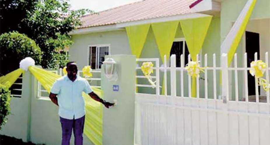 Obeng Amoako poses in front of his house