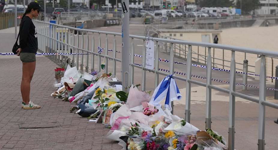 A woman stands at a flower tribute at Bondi Beach in Sydney, Australia, on December 16, 2025. -  Mark Baker, AP