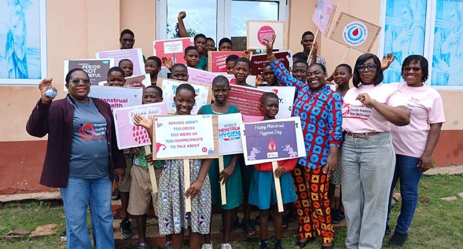 Madam Rejoice Dzifa Tamkloe - Founder of WIN (first on the left), Madam Beatrice Amesawo - PRO for WIN (Second from the right) followed by Madam Eyra Kpe (third on the right) in a photograph with some school children from participating schools in Matse at the Menstrual Hygiene Day Celebration.