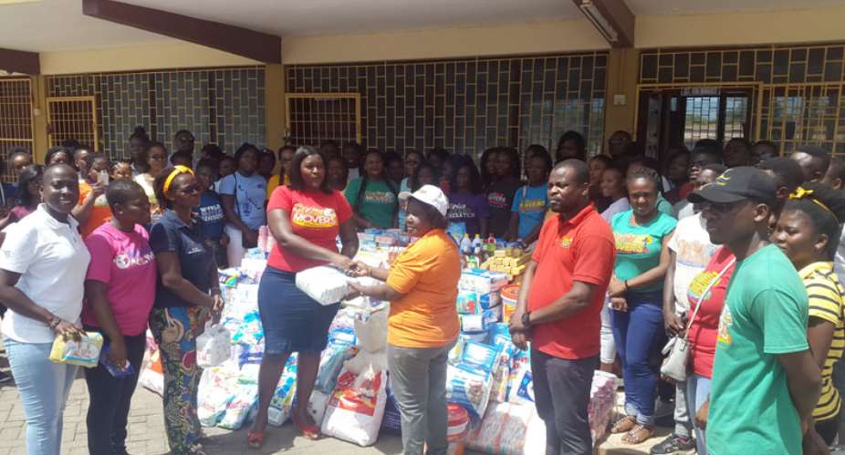 Sarah Meme, a representative of the choir, handing over the items to Madam Christina Addo, while Pastor Albert Ayittey Nii Tettey and the choir look on