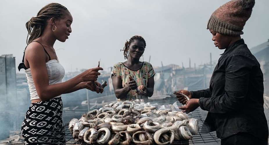 Women make smoked fishes - locally called Okporoko - at Egede informal settlement in Port Harcourt, Nigeria. - Source: YASUYOSHI CHIBAAFP via Getty Images