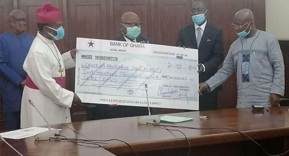 Archbishop Justice Ofei Akrofi receiving the dummy cheque from thw speaker of parliament