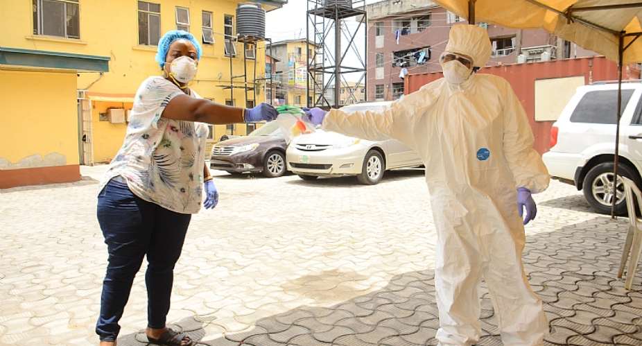 A health worker collecting sample test kits from a nurse during a community COVID-19 testing campaign in Lagos.  - Source: Photo by Olukayode JaiyeolaNurPhoto via Getty Images