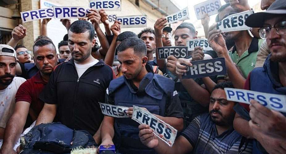 Mourners and colleagues holding press signs surround the body of Al-Jazeera Arabic journalist Ismail al-Ghoul, killed along with his cameraman Rami al-Refee in an Israeli strike during their coverage of Gazas Al-Shati refugee camp, on 31 July, 2024. -  Omar Al-Qattaa / AFP
