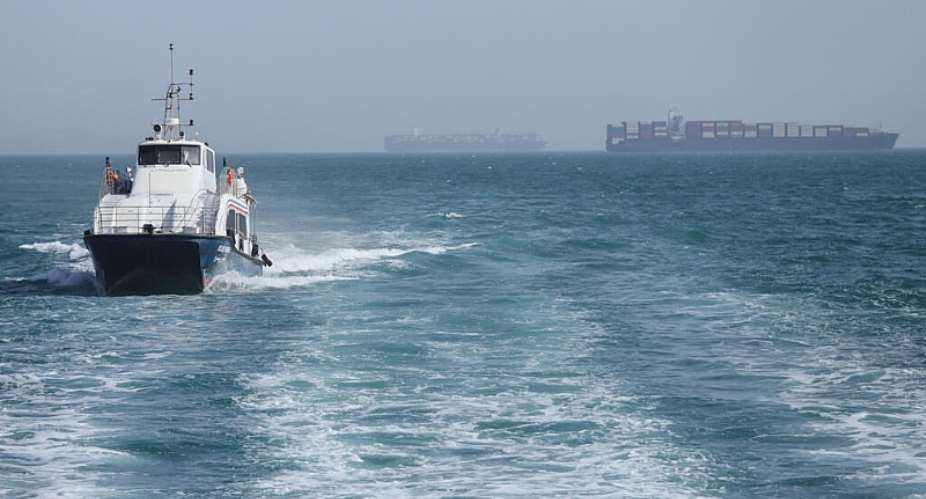 A patrol boat moves through the water as cargo ships sit at anchor in the Strait of Hormuz off Bandar Abbas, Iran, Saturday, 2 May 2026. - AP - Amirhosein Khorgooi