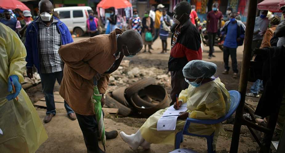 A public health worker takes details from a man volunteering to be tested for COVID-19 in the bustling Kawangware market in Nairobi.  - Source: Tony KarumbaAFP via Getty Images